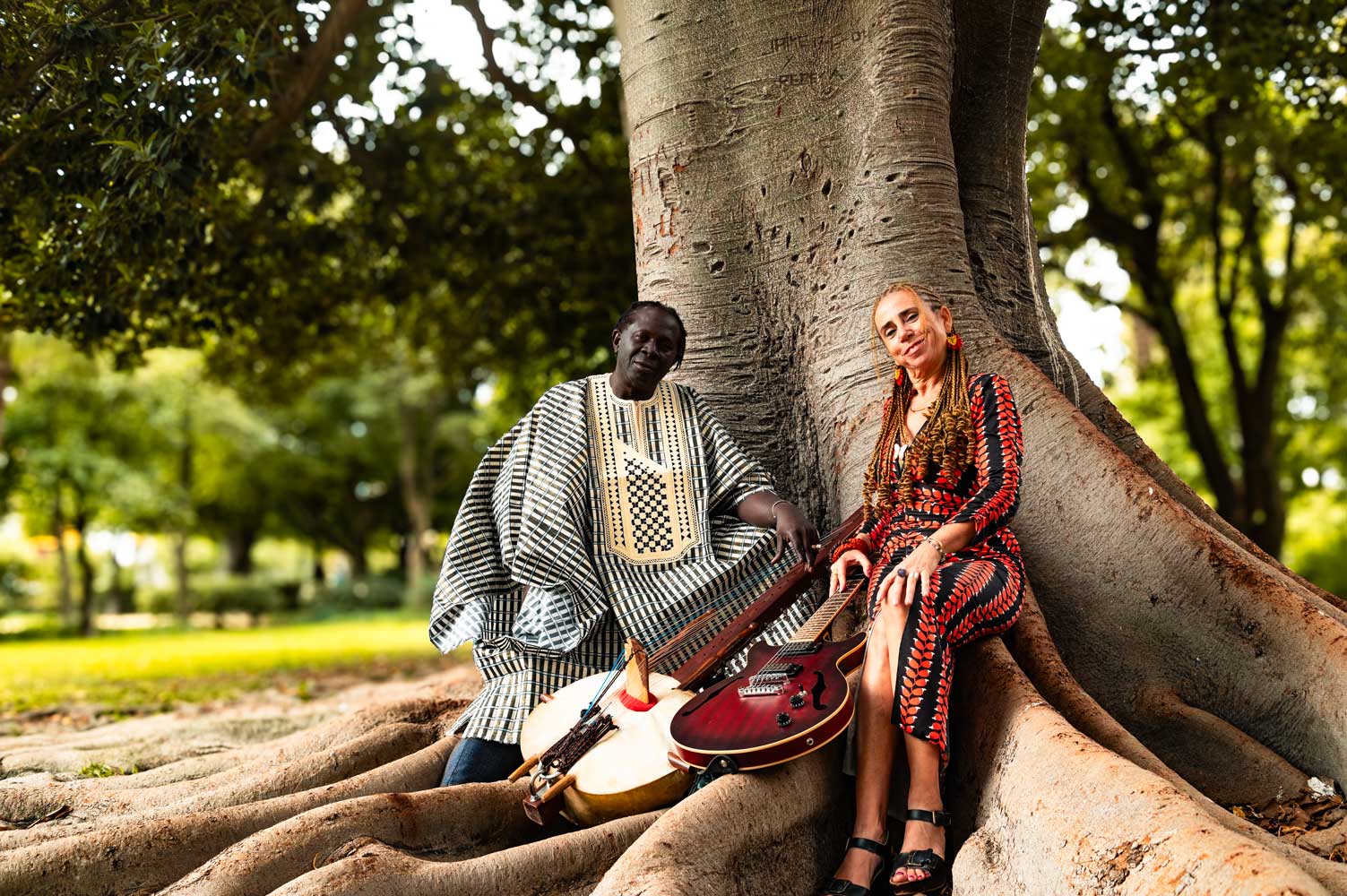 DUO ABARIKA mujer y hombre musicos sentados debajo de un arbol<br />